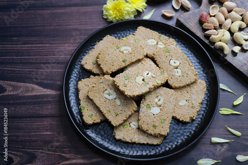 Til gajak, a traditional Indian winter sweet made with sesame seeds, jaggery, ghee, and dryfruits. Crunchy til chikki festive treat for Makar Sankranti. Tilgul. sesame candy. Copy Space. Winter food.