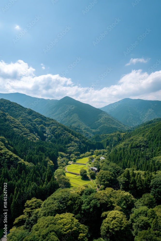Naklejka premium Scenic view of lush green valley and mountains under a clear sky