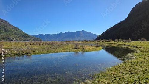 Beautiful landscape of Lake Caburgua on a sunny day, featuring blue water, mountain scenery, and a beach. Popular natural destination near Pucón, Chile.