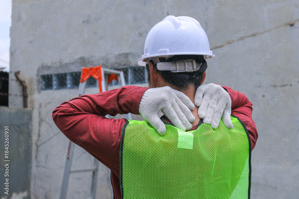 Fototapeta premium Closeup of Construction Worker Holding Injured Wrist, Wearing Gloves and Safety Vest, Near Ladder