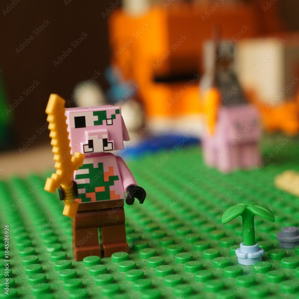 Fototapeta premium Minecraft zombie pigman toy figure holding a golden sword on a green baseplate