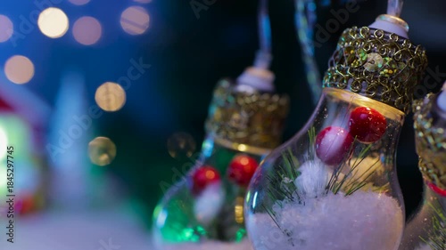 Large light bulbs decorated inside on a semi-blurred background with a house and Christmas trees with a yellow car