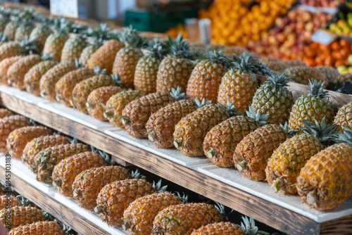 Photos A vibrant display of unique São Miguel pineapples stacked on wooden crates at a