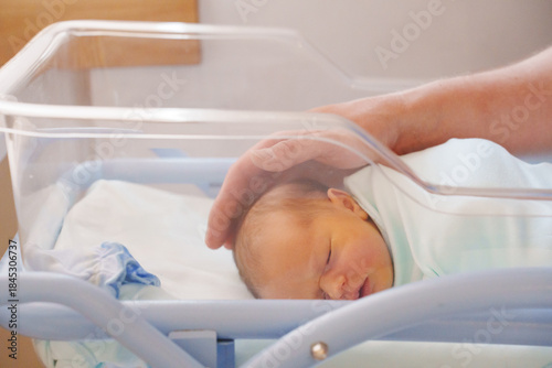Fotografie Newborn baby resting in a hospital bassinet during day