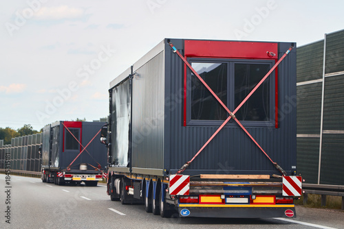 Trucks hauling prefabricated homes on open road