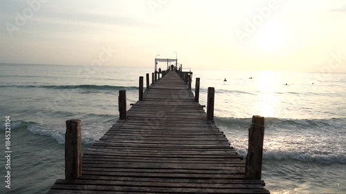  wooden bridge and resting area for tourists to watch the sunset, with mountains in the background. This landmark bridge is located on Koh Kood Island, Trat Province, Thailand.
