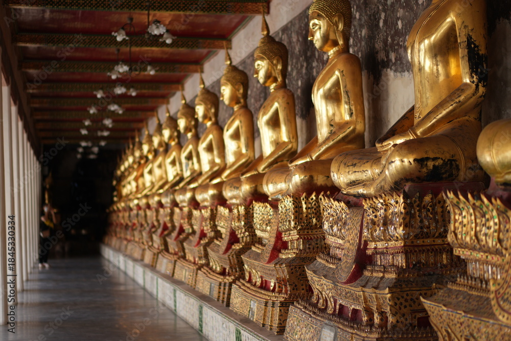 Fototapeta premium Buddha Statues in Corridor of Wat Suthat, Bangkok Thailand - One of Famous Ancient Temple in Bangkok