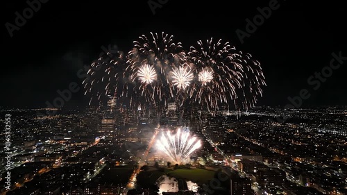 Spectacular Nighttime Fireworks Display Exploding Over a Vibrant City Skyline with Dazzling Lights from a High Vantage Point