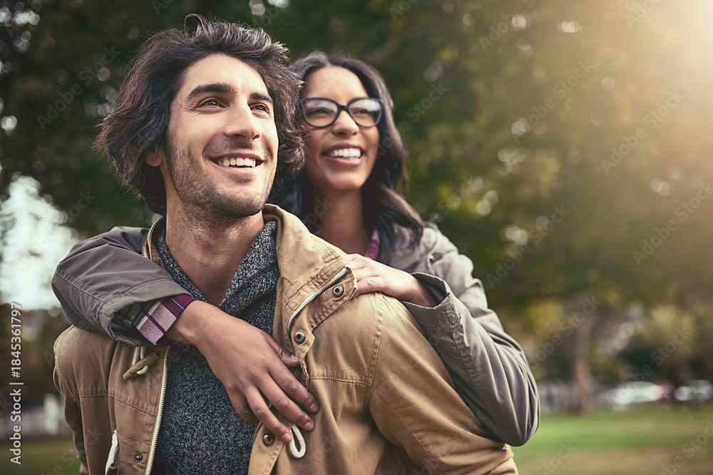 Fototapeta premium Couple, piggy back and smile in park with care, bonding or thinking on adventure in spring on holiday. Interracial love, man and woman with hug, playful and outdoor on vacation with game in Toronto