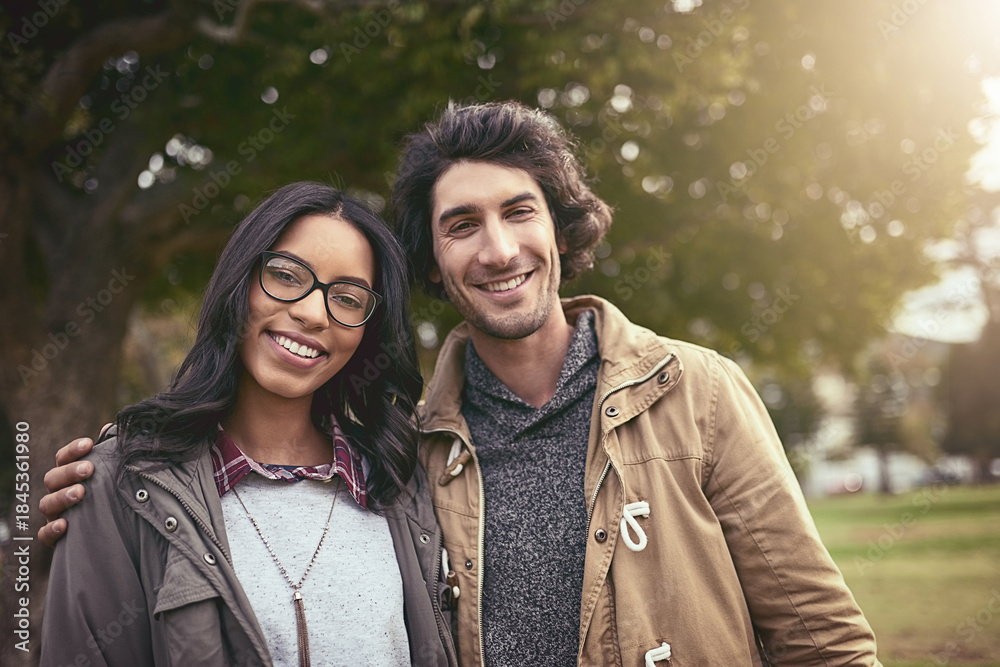 Fototapeta premium Couple, hug and smile for portrait in park with care, bonding and adventure in spring on holiday. Interracial love, man and woman with embrace, pride or outdoor on vacation with connection in Toronto