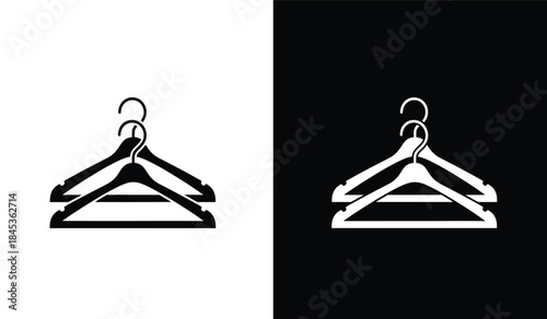 A striking visual contrast depicts two identical clothing hangers one in stark white against black and the other in black against white showcasing duality