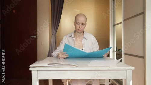 Woman with alopecia after chemotherapy checking her medical reports, concept of resilience, hope, and personal health responsibility.