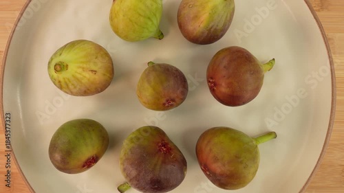 Fresh figs on plate rotation top view.