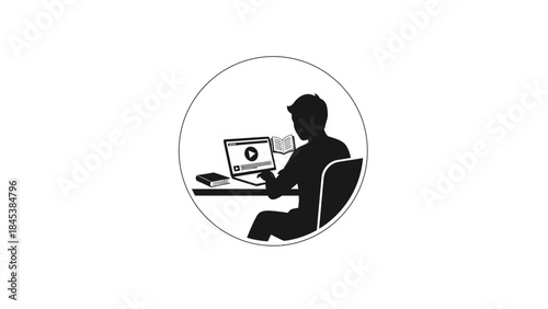 Silhouette of a person working on a laptop at a desk.