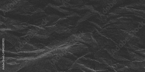 Crumpled black paper background with gritty dust speckle. Rough distress texture with halftone pattern, old worn blank for creative designs.