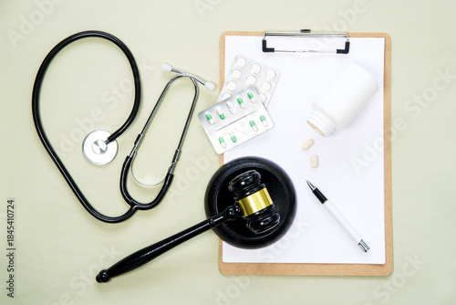 Schilderij op canvas Judge's gavel, stethoscope, secretarial and pills  on a light green background