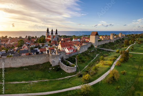 drone panorama cityscape of Visby with the medieval city wall and landmark cathedral at sunset