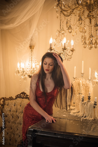 Passion brunette woman in shining red fashionable dress in vintage interior