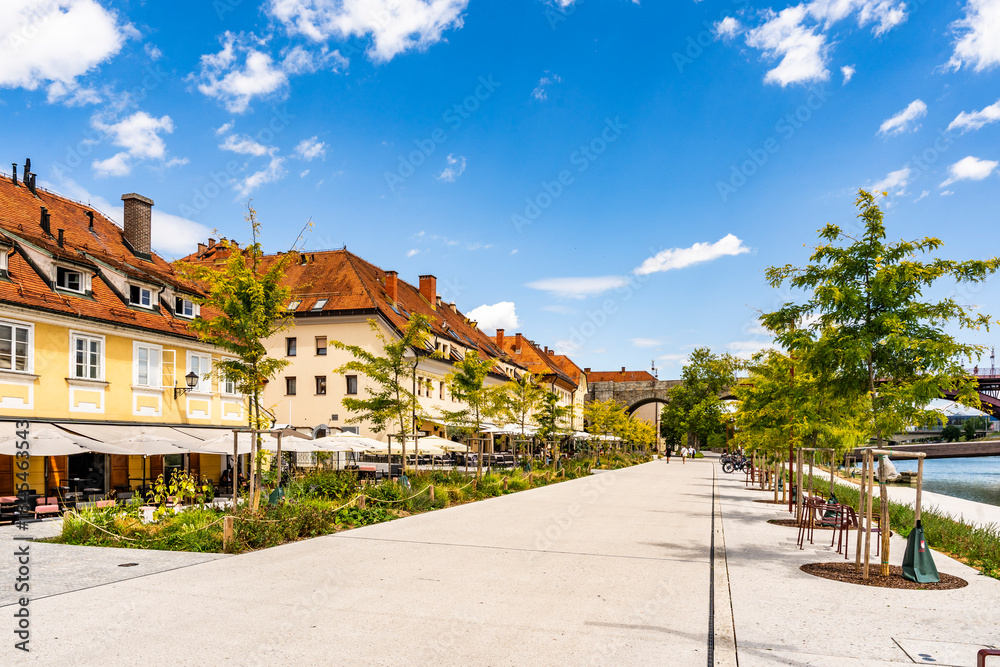 Fototapeta premium View of the Lent district along the Drava River, historic riverside promenade and cultural heart of Maribor, Slovenia, known for wine heritage, old town architecture and relaxed daily life.