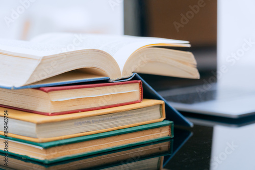 Photography A stack of several books is placed on a table, with the top book left open