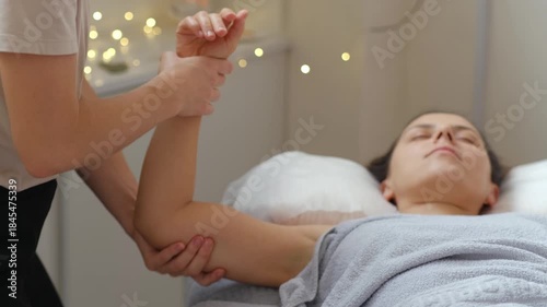 A woman is getting a massage from a woman. The woman giving the massage is wearing a white shirt