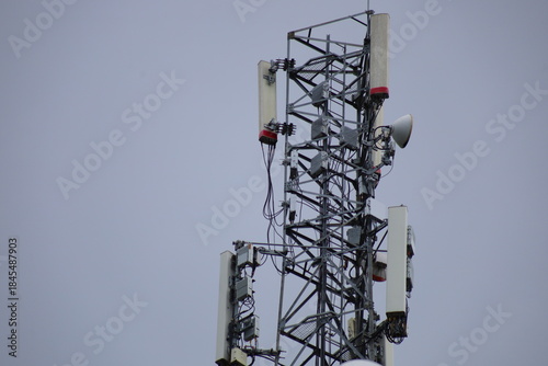 Wireless communication technology uses a steel tower with a cell phone antenna for radio signal transmission to the mobile network in the blue sky