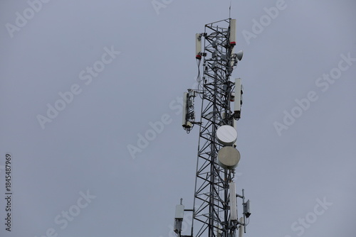 Wireless communication technology uses a steel tower with a cell phone antenna for radio signal transmission to the mobile network in the blue sky