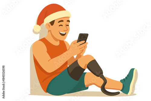 A cheerful Caucasian athlete with a prosthetic leg, wearing a Santa hat, sits on the ground, leans against a wall, and sends Christmas greetings from his smartphone
