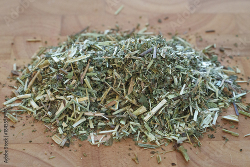 A Close-Up of Dried Meadowsweet Herb Displayed on a Wooden Surface, Emphasizing Its Unique Color, Texture, and Preparing for Herbal Applications