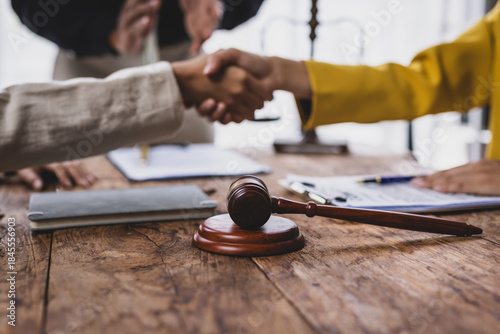Fotografia Two businesswoman hold hands after lawyers attempt to mediate a dispute