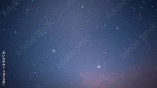 Shifting night sky star field drifting slowly across horizon over time, with pinkish cloud band
