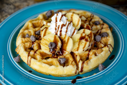 A golden waffle with bananas, peanut butter, chocolate syrup drizzle, and chocolate chips creates a decadent treat in Waukesha County, Wisconsin.