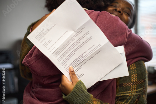 Vászonkép Black woman embracing Black teenager while holding official letter, both smiling