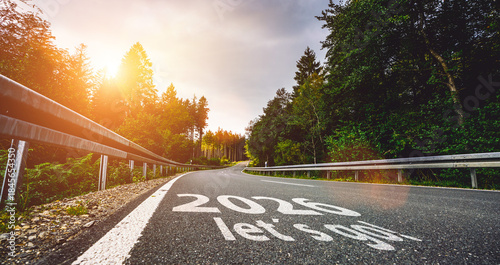 New year 2026 or start straight and beginning concept. Man ride on bike and the number 2026 start written on the road at sunset with lens flare. Concept of challenge or career path, business strategy.