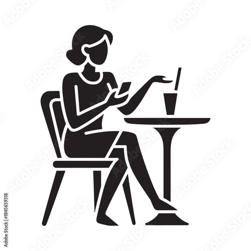 A woman sits at a table using her phone with a drink