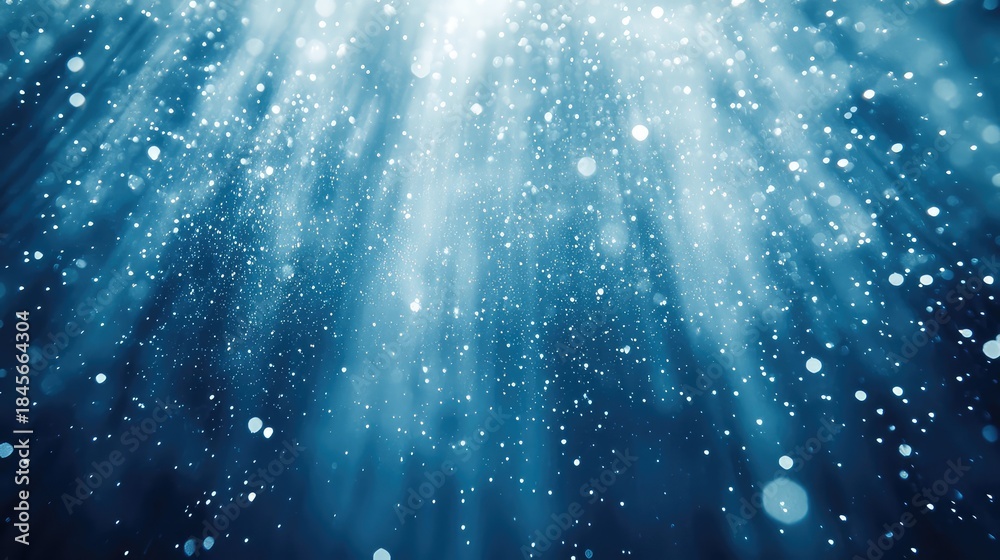 Naklejka premium Shimmering ethereal particles and soft light rays create a dreamy blue bokeh backdrop, evoking festive winter sparkle, glowing dust and magical frozen atmosphere
