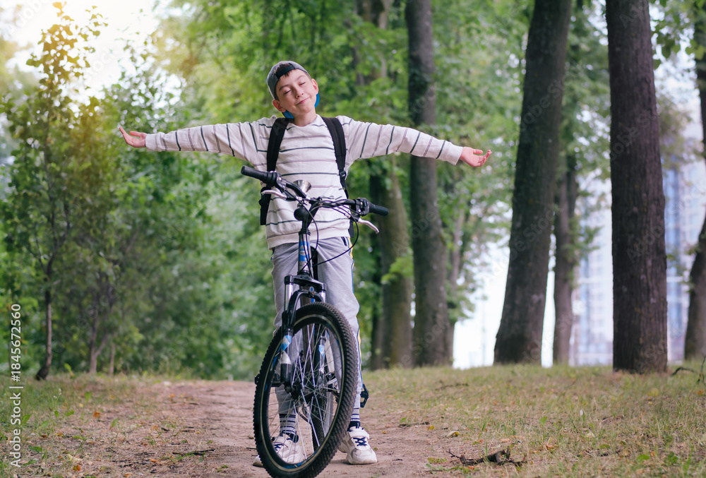 Obraz premium Active child making sports. Safety, sports, leisure with kids concept. A teen boy rides his mountain bike on a trail