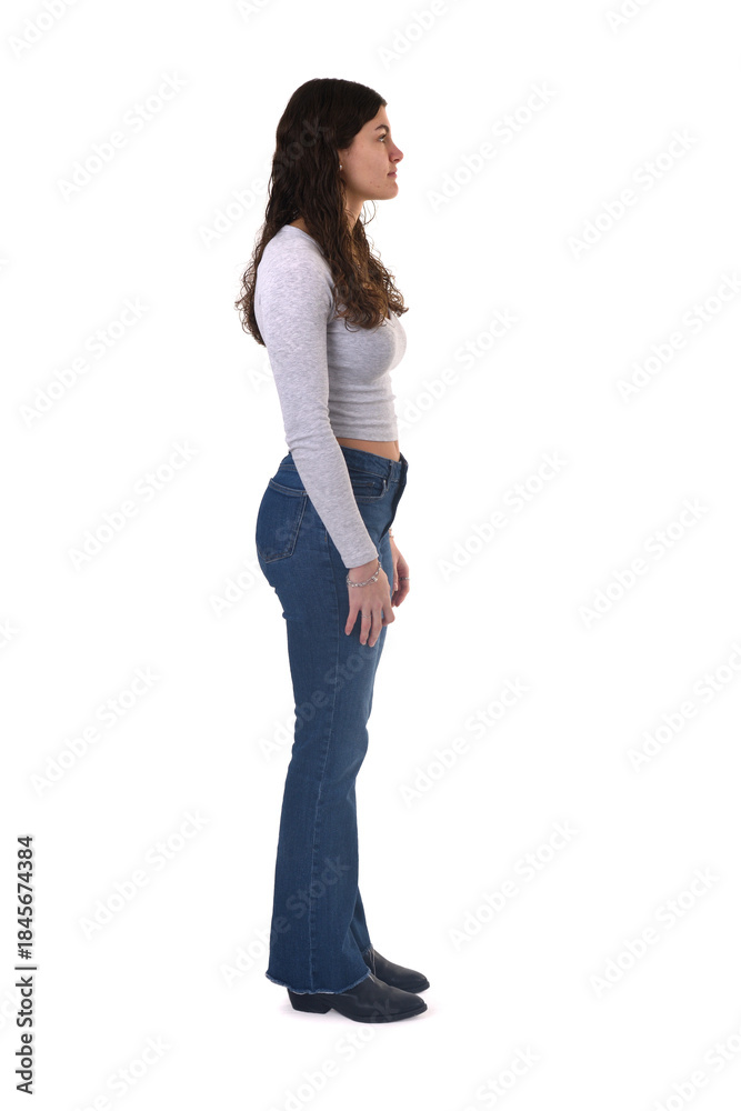 Obraz premium side view portrait of an 18-year-old girl standing on a white background.