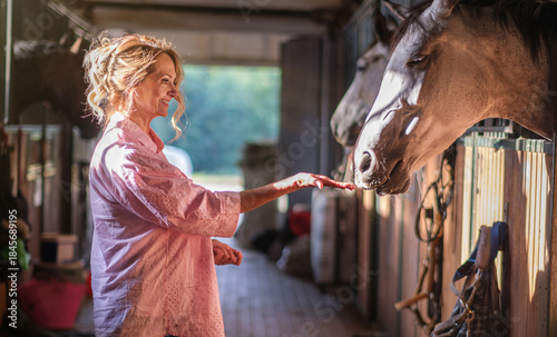 Mature female horse rider bonding with her horse