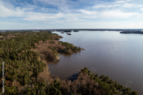 Wallpaper Mural Aerial view of the tranquil lake reflecting the scattered clouds, embraced by dense forest along the rugged shoreline, Angso, Vastmanland County, Sweden. Torontodigital.ca