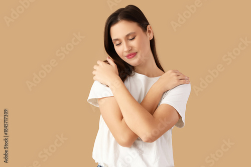 Young woman hugging herself...