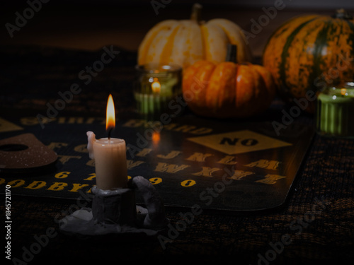 Candle burning with spirt board and pumpkins