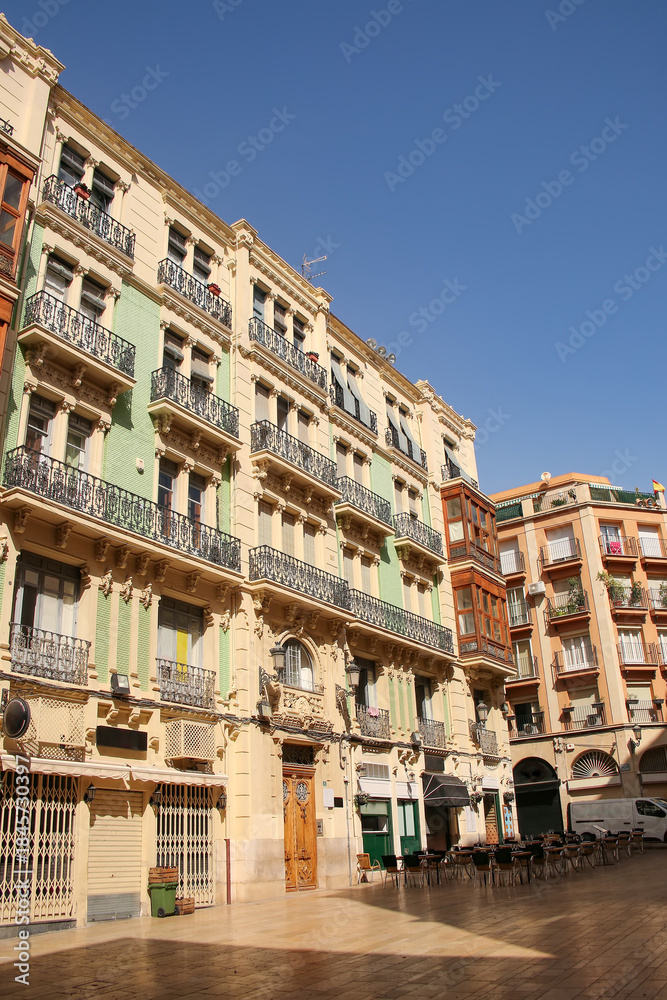 Obraz premium Beautiful and historic buildings surrounding the Plaza de Santa Maria in the old town, with ornate iron balconies and brick work, Alicante, Costa Blanca, Spain.