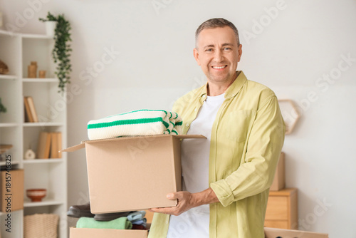 Mature man holding box with...