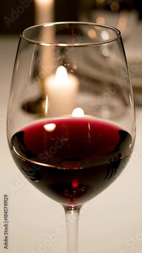 Red wine glass candlelight reflection creates warm romantic table dinner close up stemware beverage elegant cozy dining romantic ambiance beverage