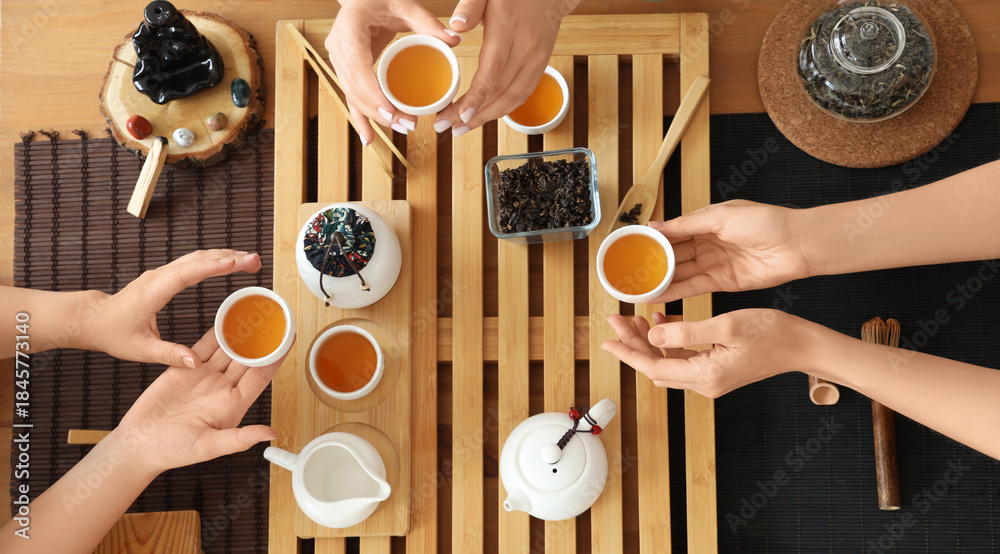 Fototapeta premium Women with Asian tea in cups, top view