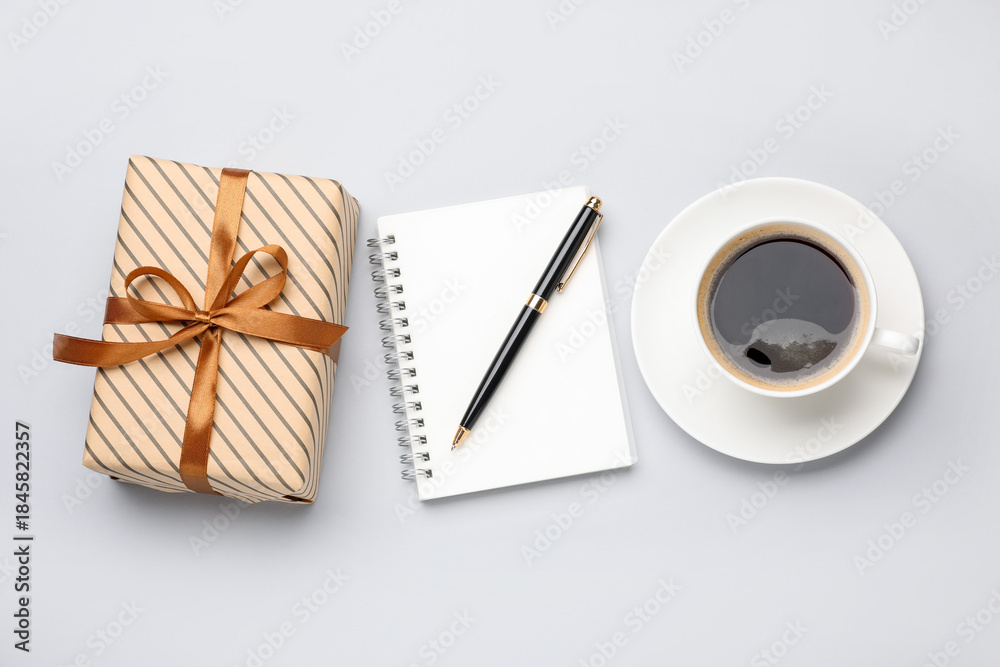 Obraz premium Beautiful gift box, notebook, pen and cup of coffee on white background, flat lay