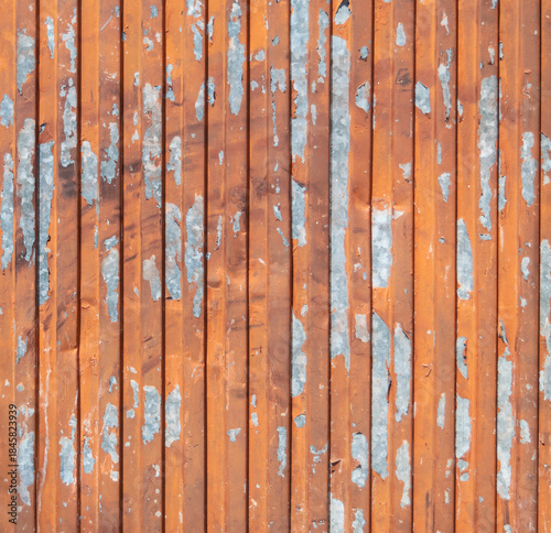 Rust-colored corrugated metal surface with vertical line pattern and distressed paint