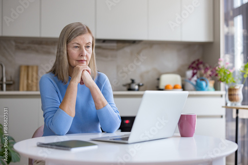 Fotografi Senior woman thoughtfully pondering while working or studying from home, connect