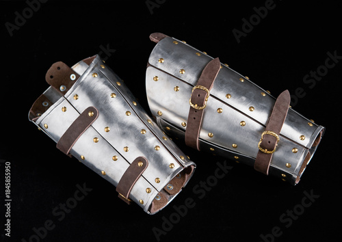 Quadro em tela Medieval Armored Bracers with Leather Straps Against Black Background